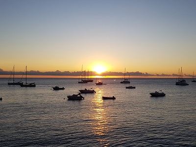 The earth turning on its axis, causing the sun to disappear behind the horizon.